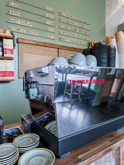La Marzocco espresso machine at Better Burnt café with timber counter and minimalist menu wall.