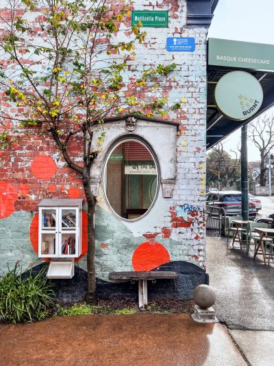 Painted brick wall and street art next to Better Burnt café entrance.