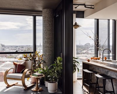 Open-plan London apartment with winter garden, marble kitchen island, and curated furniture.