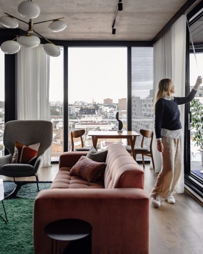 London apartment living room with velvet sofa, city views, and modern furniture designed by The Stylesmiths.