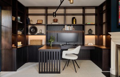 Contemporary London home office with dark wood shelving, modern desk, and neutral tones.