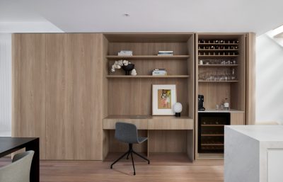 Bespoke timber joinery with integrated desk and bar area in a London apartment.