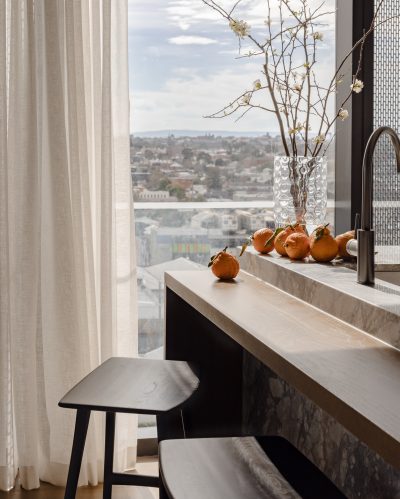Kitchen bar seating in a London apartment with marble island and city views.