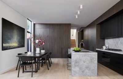 Contemporary London kitchen with marble island, dark cabinetry, and open dining area.