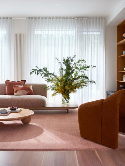 London living room with earthy tones, boucle sofa, terracotta accents, and natural light.