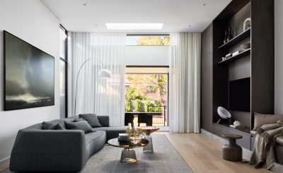 Modern London living room with dark timber joinery, sectional sofa, and floor-to-ceiling windows.