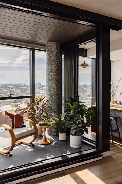 Winter garden in a London apartment with tiled cylindrical column and indoor greenery.