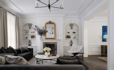 Elegant London living room with white walls, decorative arch niches, and modern black sofas designed by The Stylesmiths.
