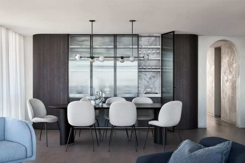 Contemporary London dining room with marble cabinetry, modern pendant lighting, and upholstered dining chairs styled by interior designers.