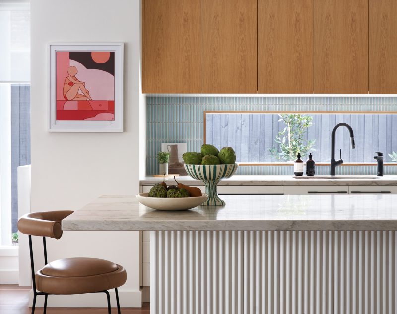 London kitchen interior with marble island, timber cabinetry, and curated artwork by The Stylesmiths.