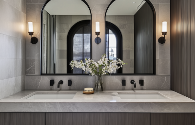 Clapham bathroom interior with marble vanity, black fixtures, and arched mirrors designed by The Stylesmiths London.