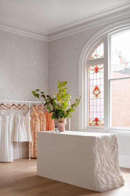 Dalston boutique interior with plaster counter, stained glass window, and natural light designed by The Stylesmiths London.