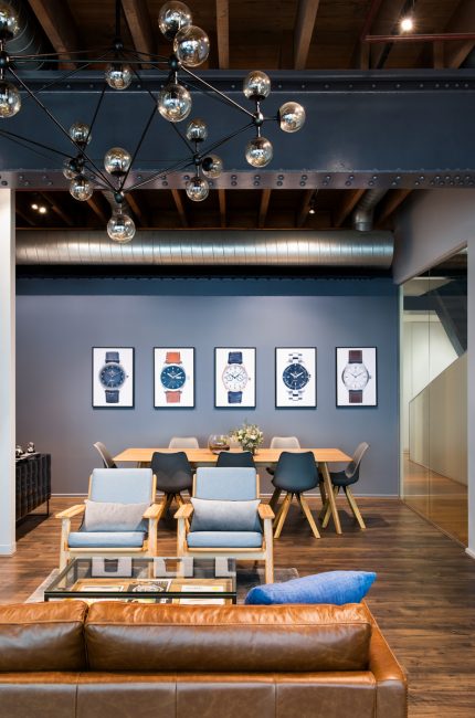 Finchley office interior with exposed beams, leather sofa, and pendant lighting designed by The Stylesmiths London.