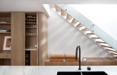 Kentish Town kitchen with marble benchtop, natural timber joinery, and sculptural staircase designed by The Stylesmiths London.