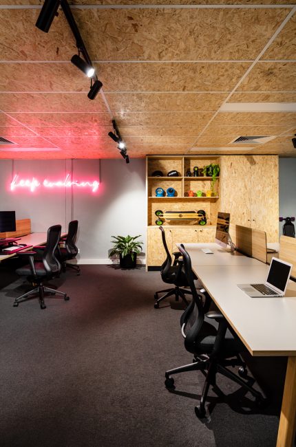 Kentish Town creative office with modern workstations, neon signage, and plywood detailing designed by The Stylesmiths London.