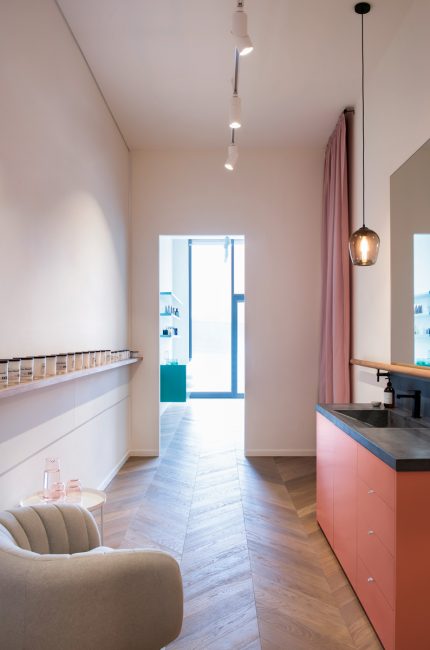 Kentish Town beauty salon interior with blush cabinetry, pendant lighting, and chevron flooring designed by The Stylesmiths London.