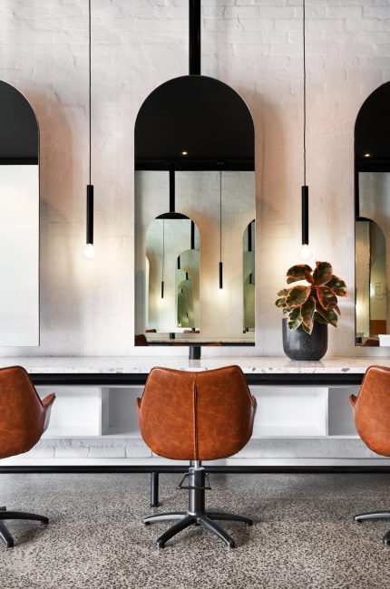 Lambeth commercial interior with arched mirrors, leather chairs, and minimalist lighting designed by The Stylesmiths London.