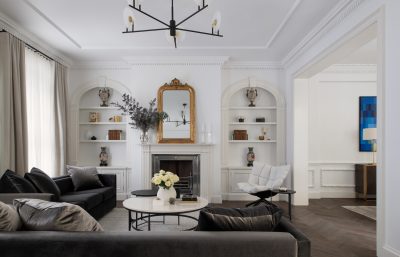 Lambeth living room with classic white walls, dark velvet sofas, and gold mirror designed by The Stylesmiths London.