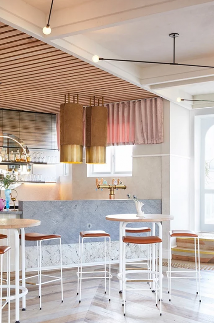 Lambeth restaurant interior with marble bar, gold pendant lighting, and timber ceiling designed by The Stylesmiths London.