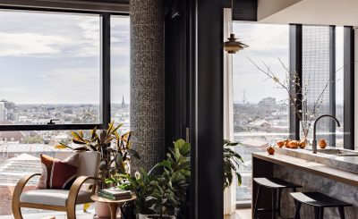 Modern London apartment with marble kitchen island, timber accents, and indoor plants designed by The Stylesmiths London.