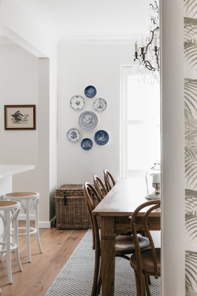 London dining room with wooden table, blue decorative plates, and natural light.