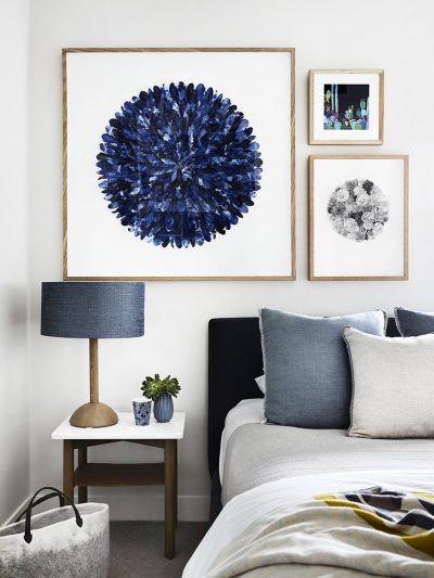 London bedroom with blue textiles, framed art, and layered textures styled by The Stylesmiths London.
