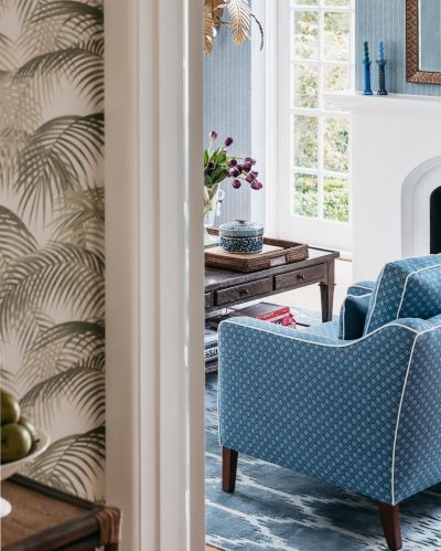 Entryway leading to a blue-toned living room with vintage furnishings in a London heritage home.