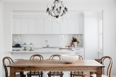 White kitchen with herringbone splashback and timber dining table in a London home designed by The Stylesmiths.