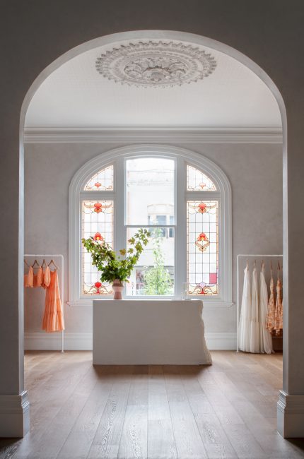 Muswell Hill retail boutique with arched window, timber floors, and soft neutral palette designed by The Stylesmiths London.