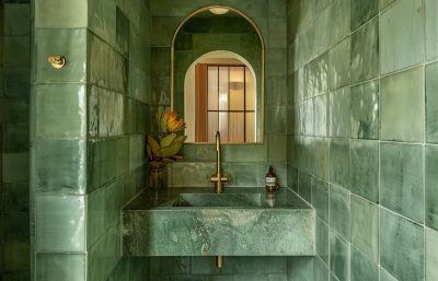 Luxurious Pimlico bathroom interior featuring green tiles, marble basin, and brass fittings by The Stylesmiths London.