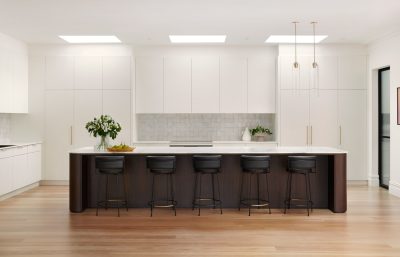 Wimbledon kitchen interior with white cabinetry, marble island, and brass pendant lights designed by The Stylesmiths London.