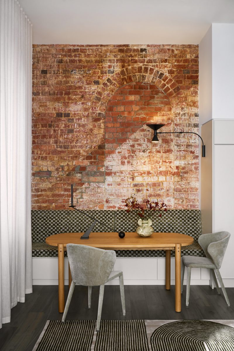 Industrial-style London dining nook with exposed brick wall and modern lighting design.
