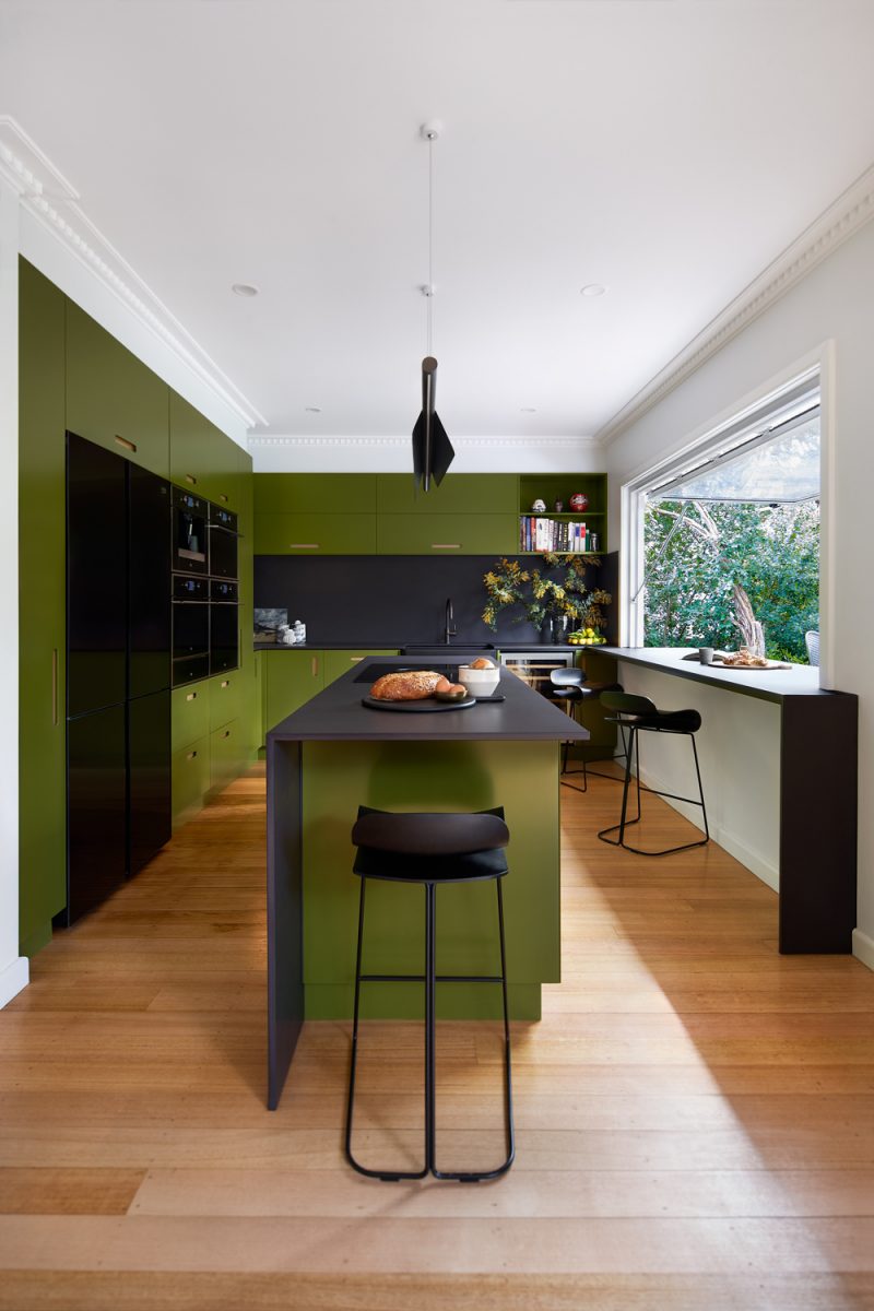 Mid-century inspired London kitchen with olive green cabinetry and black accents.
