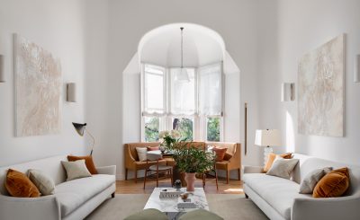 Minimalist London living room with soft neutral palette, arched bay window, and natural light.