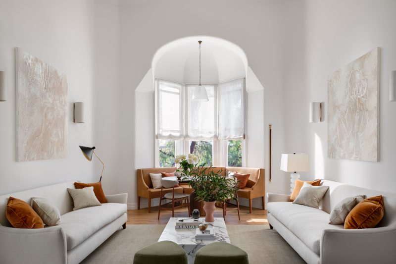Minimalist London living room with soft neutral palette, arched bay window, and natural light.