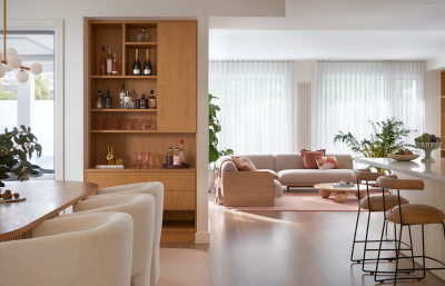 Scandinavian open-plan living space with warm timber joinery, soft neutral seating and bright natural light.