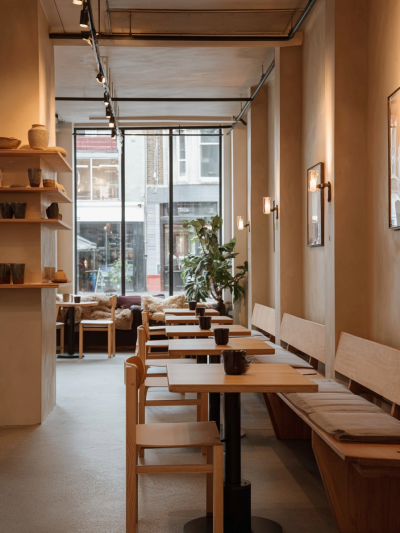 Japanese-inspired café interior with warm timber seating, soft ambient lighting and calm, minimalist tonality.