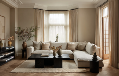 Japandi living room with neutral sofa, black timber coffee table, warm textiles and shoji-style screen detailing.